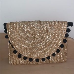 Shiraleah basket weave clutch with black pompoms